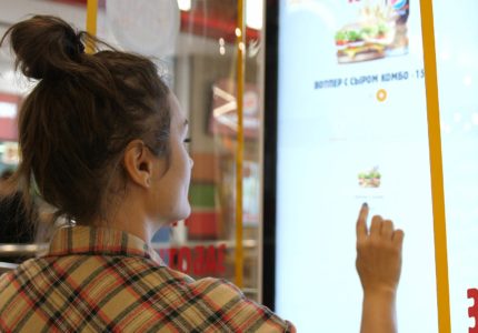 A woman ordering fast food at a digital menu